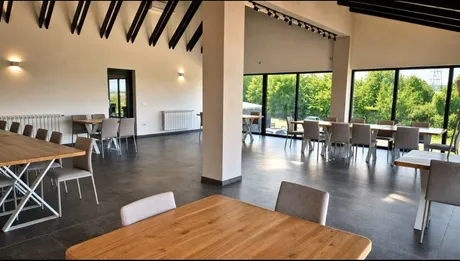 Salonul interior, cu mese din lemn masiv și lumină naturală